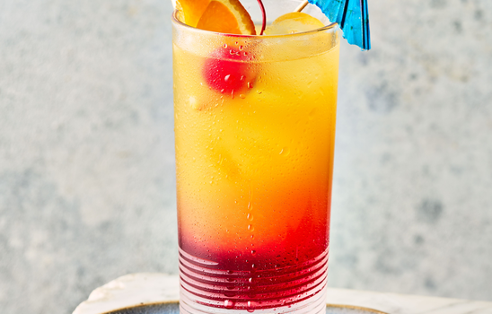 Kleurrijke cocktail met citrusfruit en een parasolletje